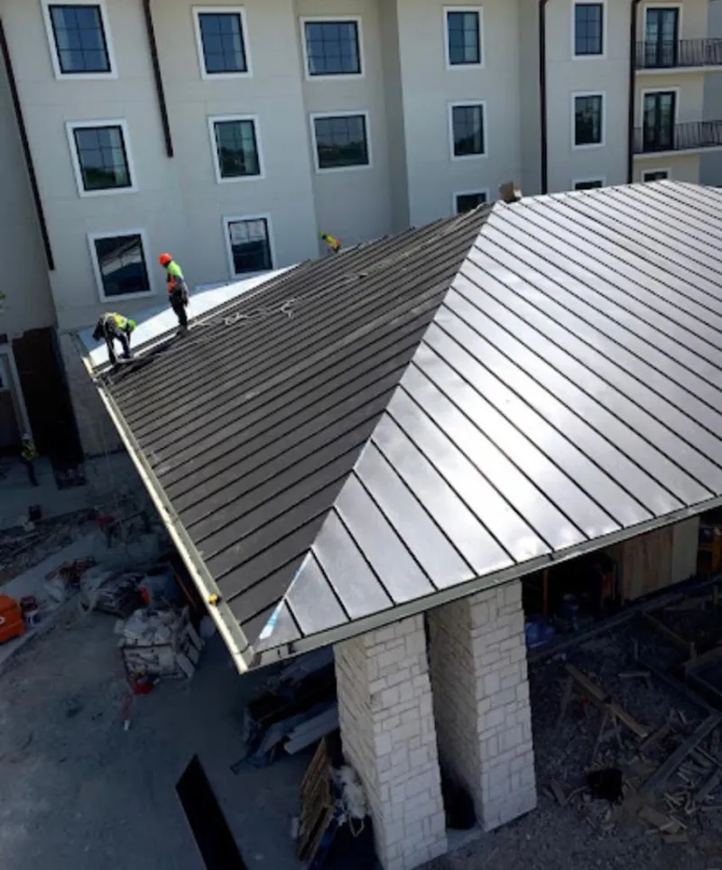 Crew installing standing seam metal roof panels on a commercial project in North Weeki Wachee